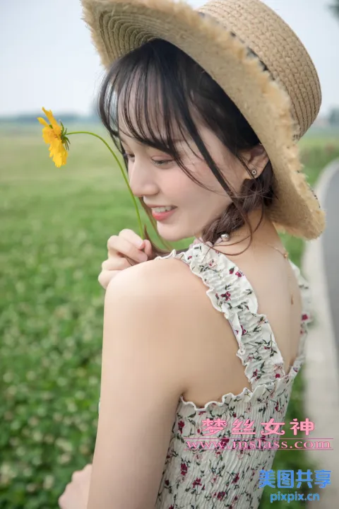 戴帽子的女人拿着一朵花的特写