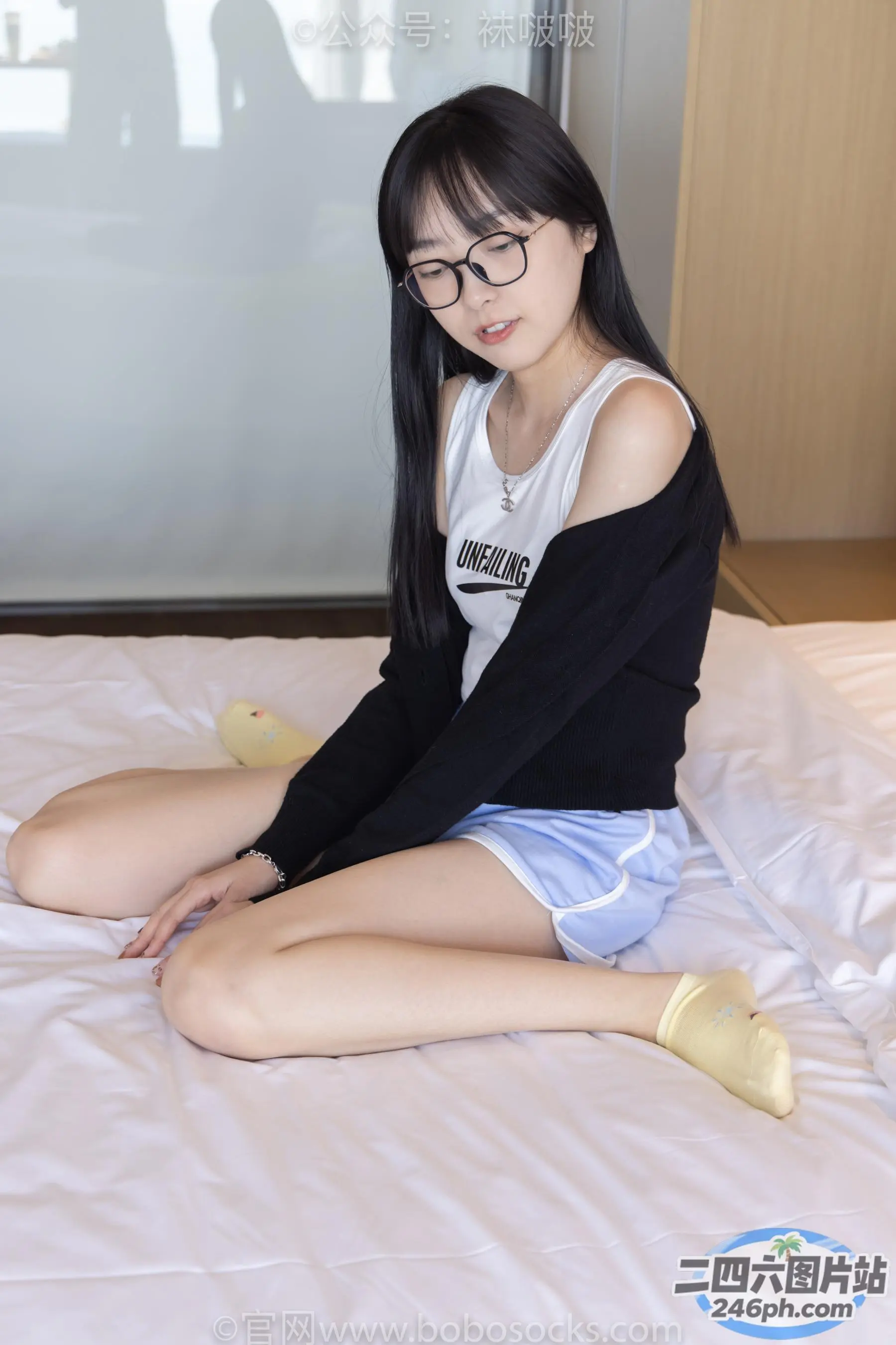 阿拉夫德亚洲妇女坐在床上，戴着一副眼镜