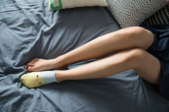 带枕头和枕头的床上的阿拉弗腿