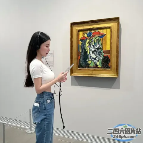 站在画前拿着手机的女人