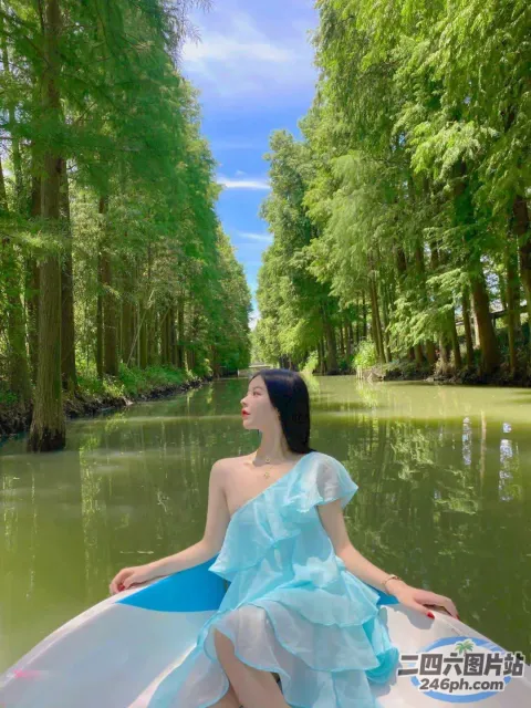 穿着蓝色连衣裙的阿拉夫德女人坐在河中的船上
