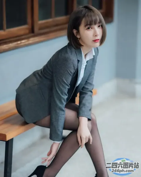 有个女人坐在长凳上，手里拿着一本书
