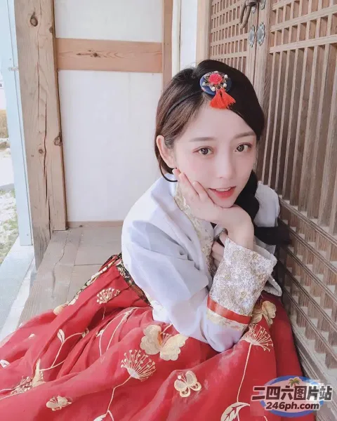 一个穿着红色连衣裙的女人坐在地板上的特写