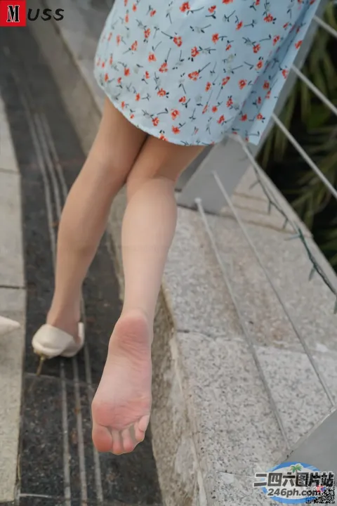 有一个女人走在人行道上，脚悬在空中