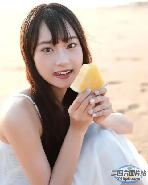 一个女人在脸上拿着一块水果的特写