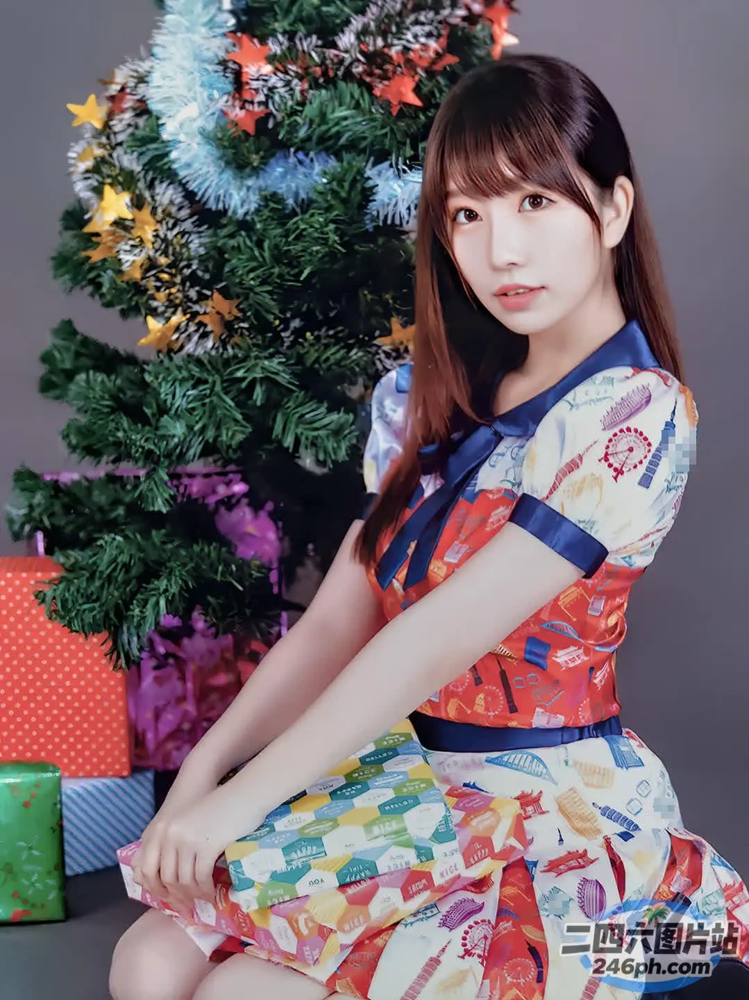 坐在圣诞树前的 araffe 亚洲妇女