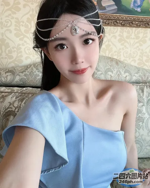 身穿蓝色连衣裙、戴着头饰的 araffe 女子坐在沙发上