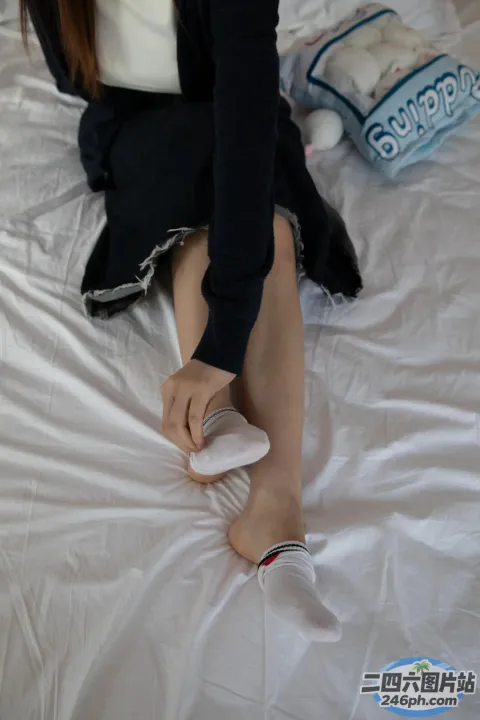 床上坐着一个女人，手里拿着遥控器