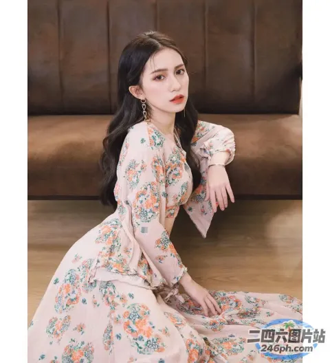 一个穿着碎花裙的女人坐在木地板上