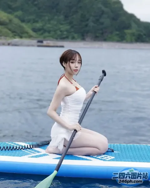 拿着桨坐在水中的桨板上的女人