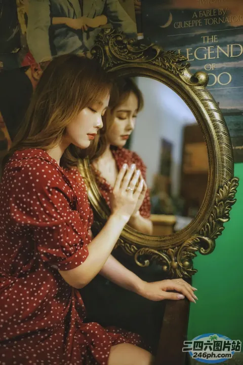 有一个女人坐在镜子前看着她的倒影
