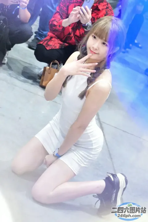 身穿白色连衣裙的阿拉伯女孩坐在地上，双手叉腰