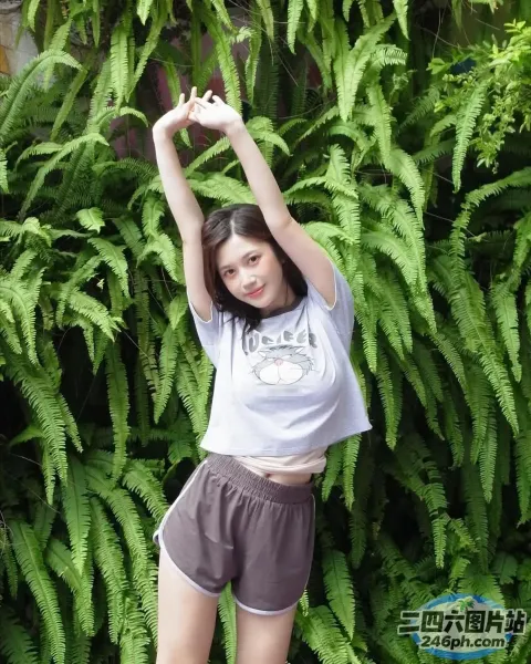 穿着短裤和 T 恤的 arafed 女人站在灌木丛前