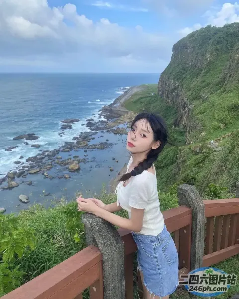 有一个女人站在俯瞰大海的木栏杆上