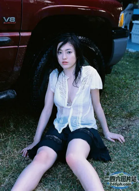 坐在卡车旁边的地上的阿拉菲德女人