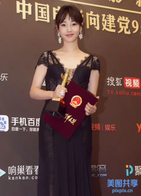 身穿黑色连衣裙的阿拉菲女人拿着红色奖