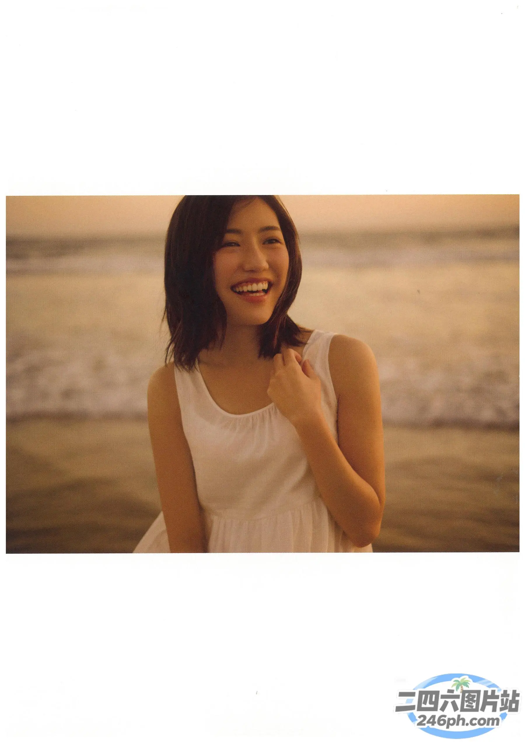 身穿白色连衣裙的阿拉夫德女子站在海边的海滩上