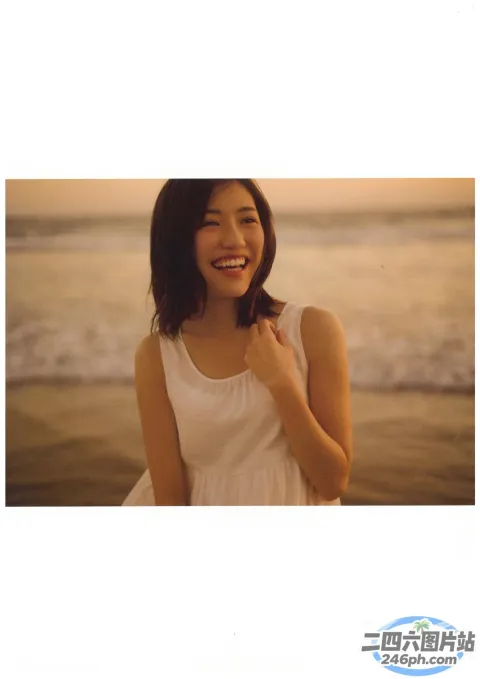 身穿白色连衣裙的阿拉夫德女子站在海边的海滩上