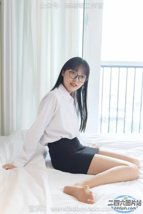 一个女人穿着白衬衫坐在床上的特写