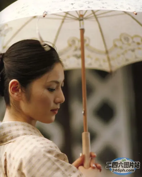 身着传统服饰的阿拉夫德妇女在院子里撑着伞