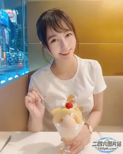 阿拉菲女人坐在桌子旁，手里拿着一碗水果和一把叉子
