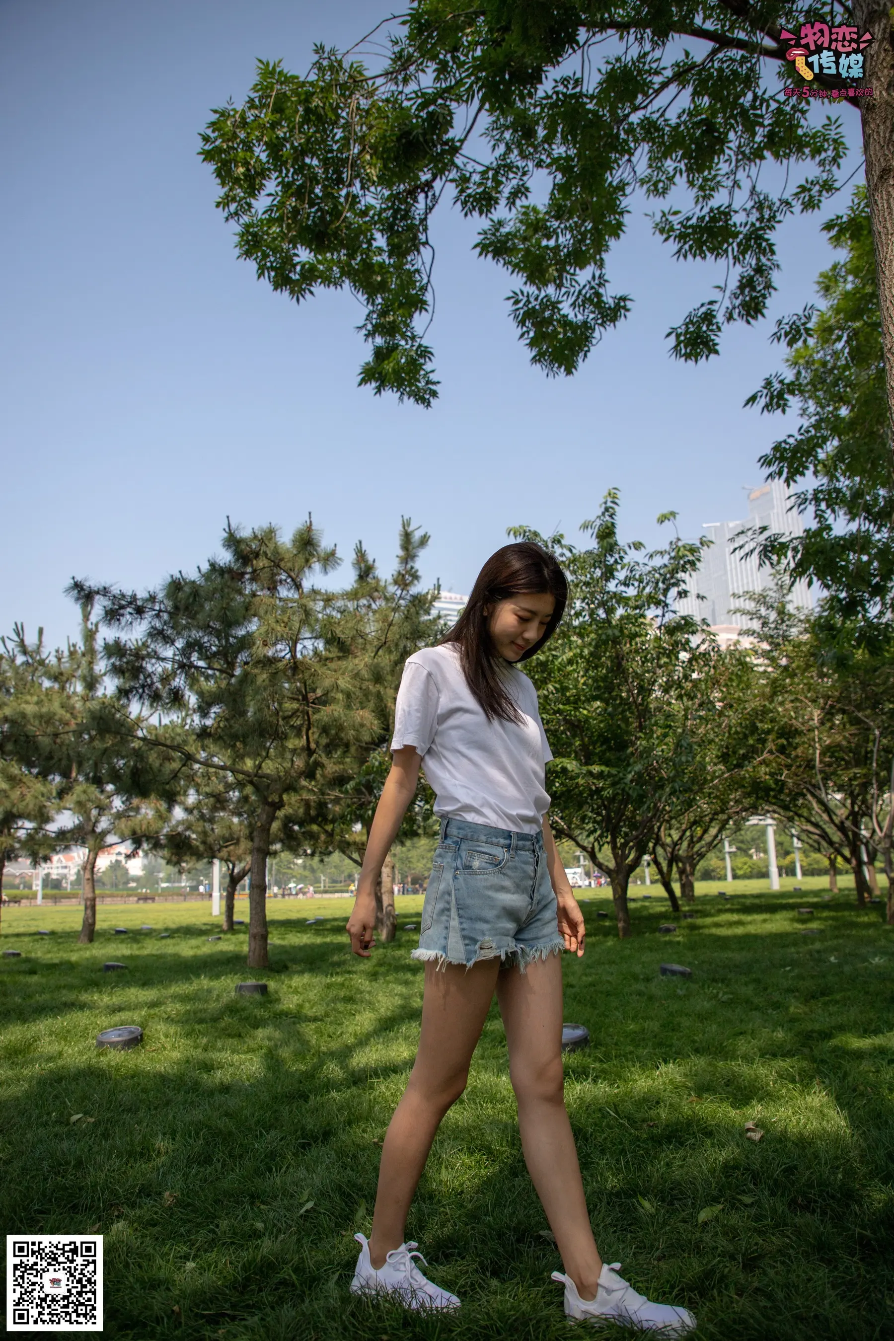 穿着白衬衫和蓝色短裤的 araffe 女孩在公园里散步