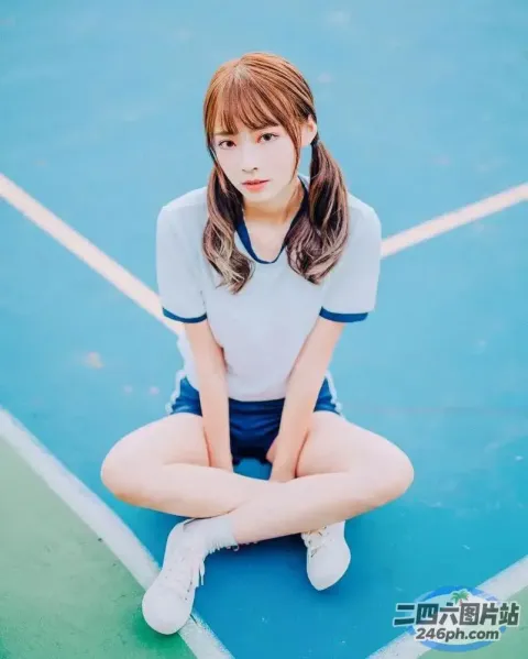 一名女子盘腿坐在网球场上