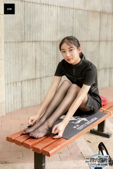 有个女人坐在长凳上，双腿交叉