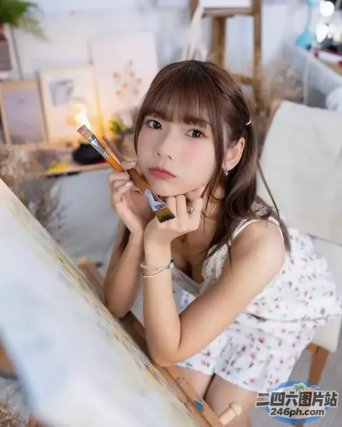 拿着铅笔和画笔坐在桌子旁的 arafed 亚洲女孩