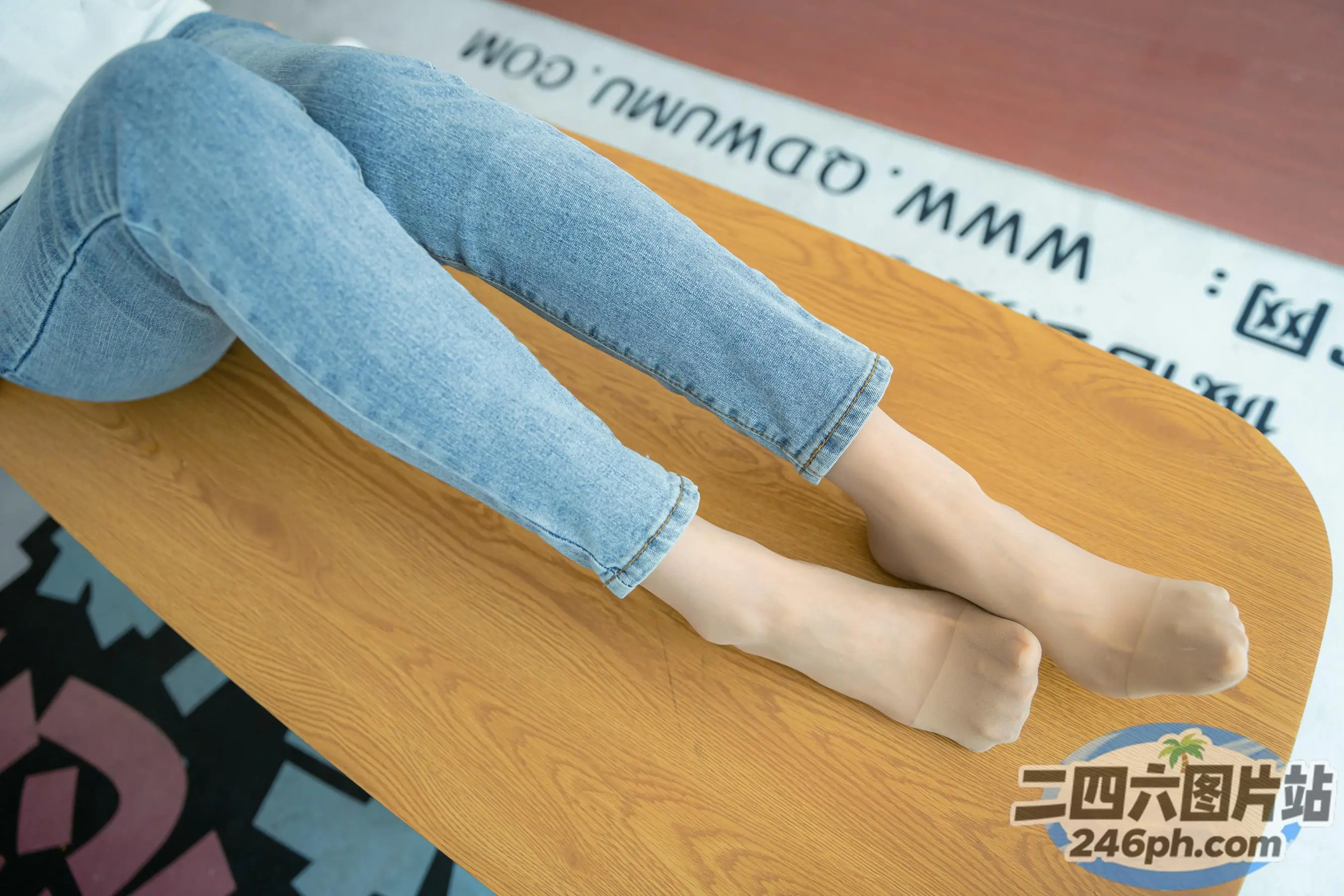 有一个女人坐在桌子上，双腿交叉