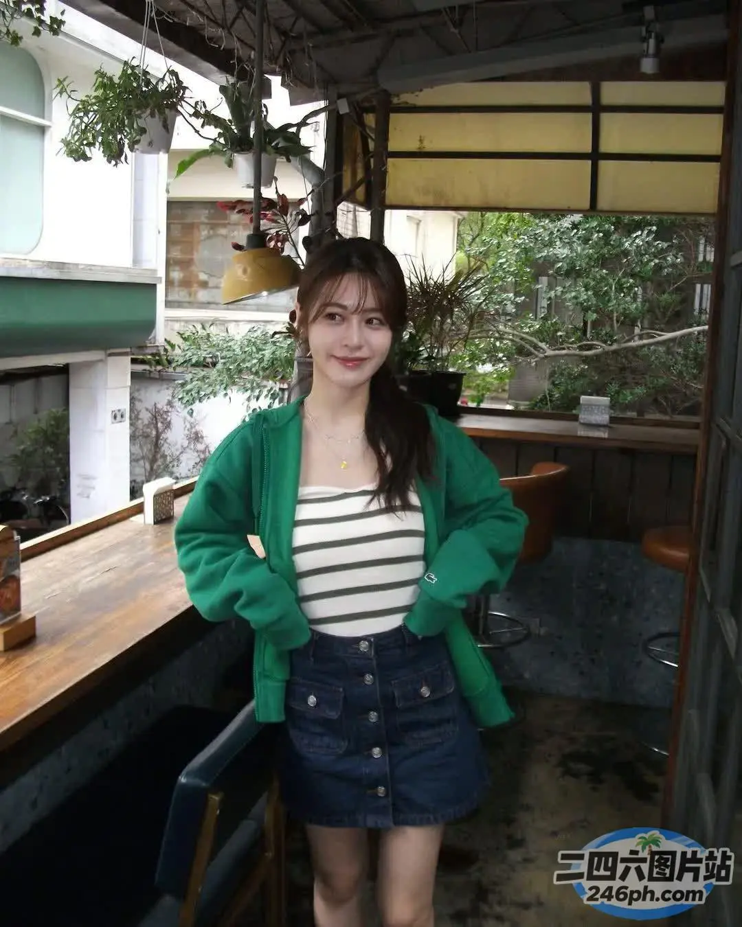 阳台上站着一个穿着绿色夹克的女人