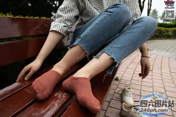 坐在长凳上的阿拉菲德女人，脚踩着一双袜子