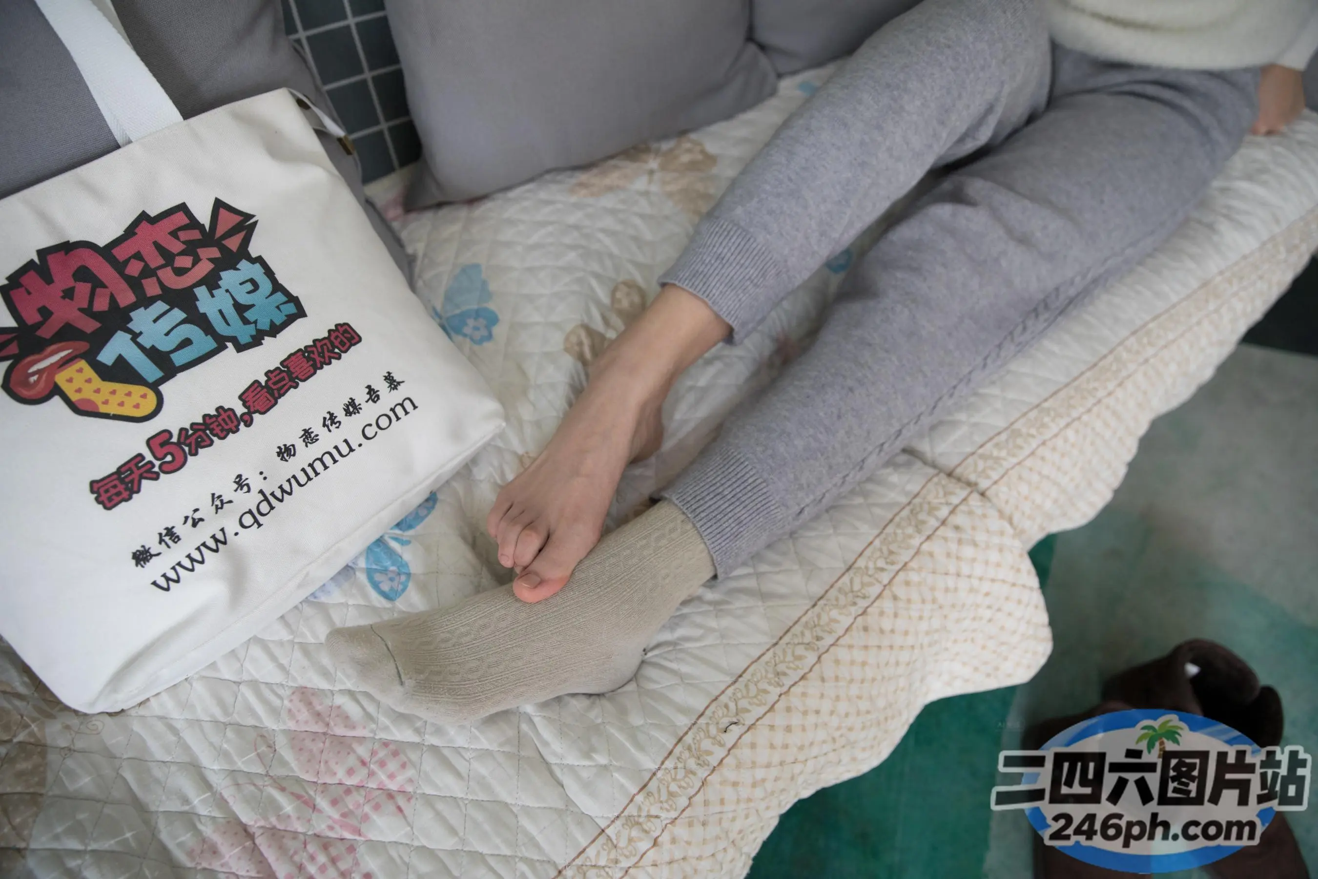 有人拿着一个包和一双鞋坐在床上