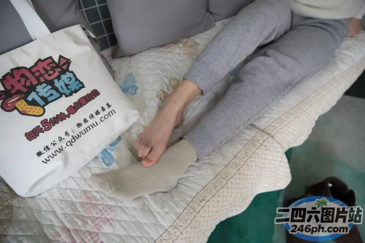 有人拿着一个包和一双鞋坐在床上