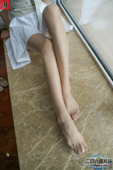 有一个女人坐在地板上，双腿交叉