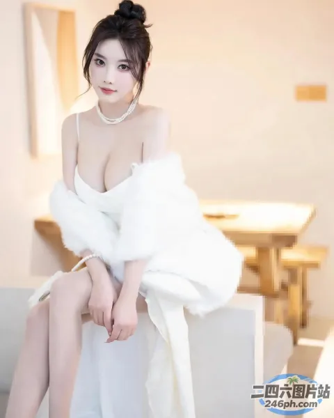 有个女人坐在沙发上，穿着白色的裙子