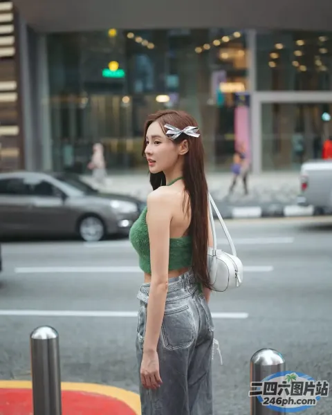 身穿绿色上衣和银色裤子的阿拉菲女子站在街上