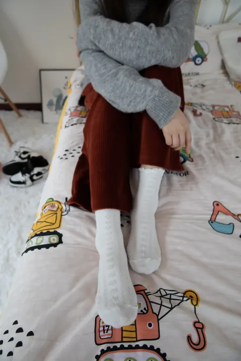 阿拉夫德女人坐在床上，手里拿着一条毯子和一条毯子