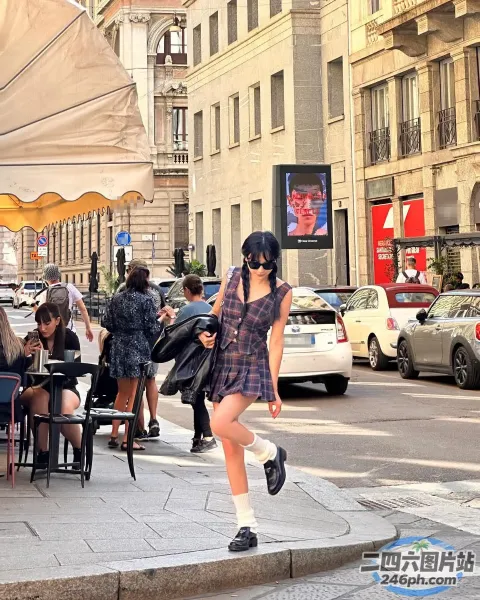 有一个女人拿着手机走在街上