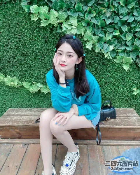 阿拉菲坐在长凳上，手里拿着一个手提包和一个钱包