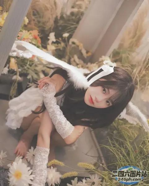 地上坐着一个女人，手里拿着一根白色的羽毛