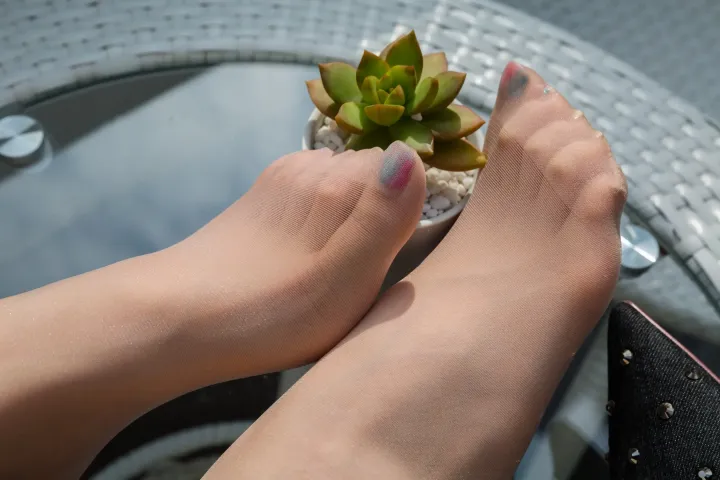 有人在桌子上的花盆里拿着一株小植物