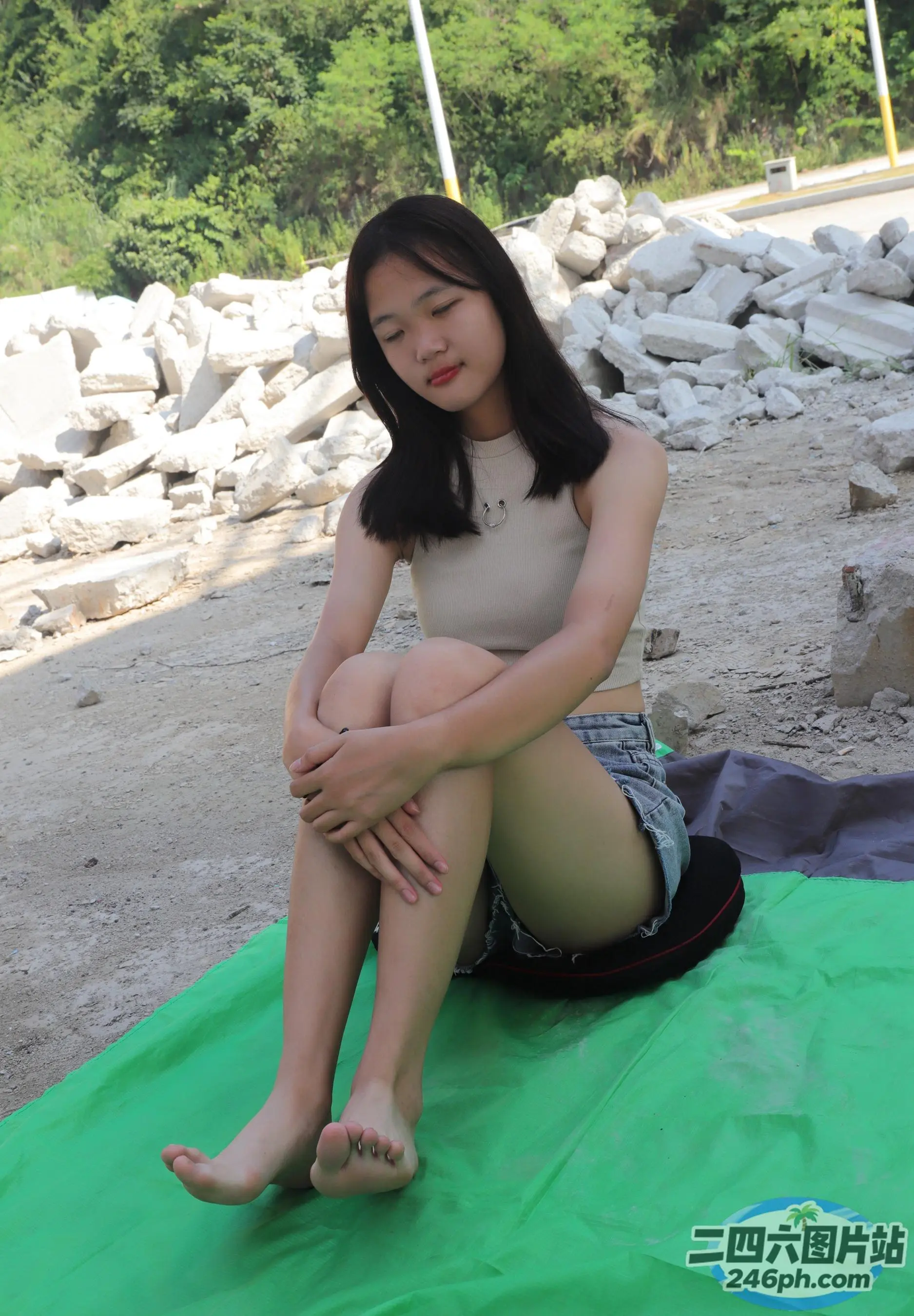坐在海滩上绿色垫子上的 Araffe 女子