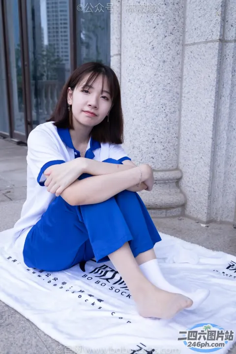 阿拉夫德女人坐在地上的毛巾上，双腿交叉