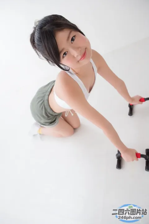 有一位年轻女子跪在地板上，手里拿着一把剪刀