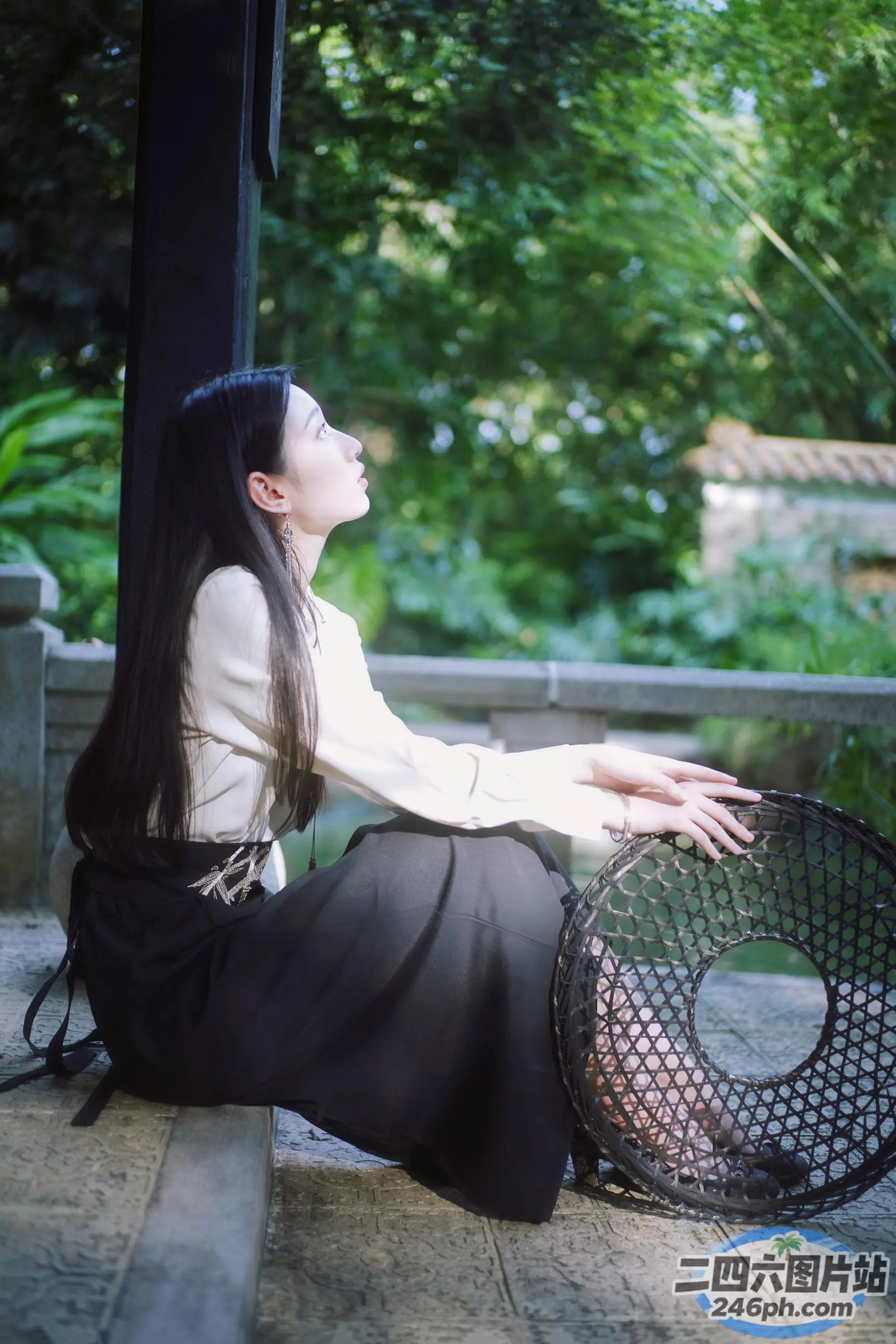 台阶上坐着一个女人，手里拿着篮子
