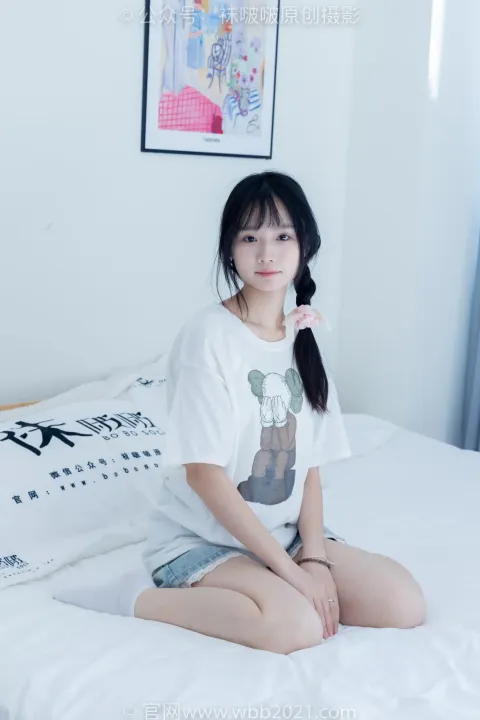 一个女人穿着白衬衫坐在床上的特写