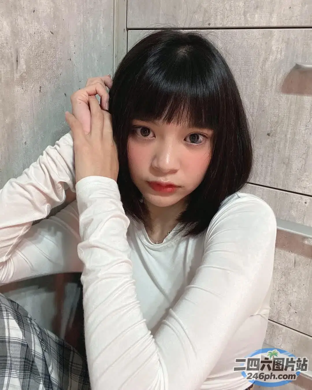 地板上坐着一个女人，手里拿着牙刷