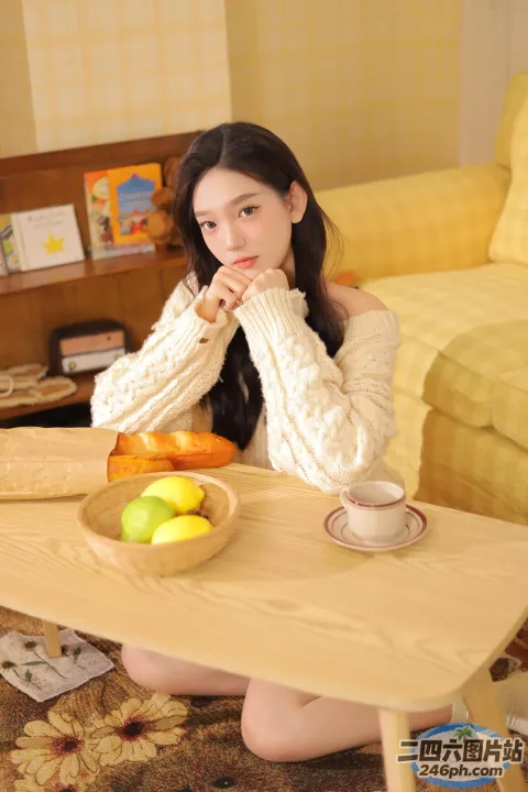 阿拉菲女人坐在桌子旁，手里拿着一碗水果