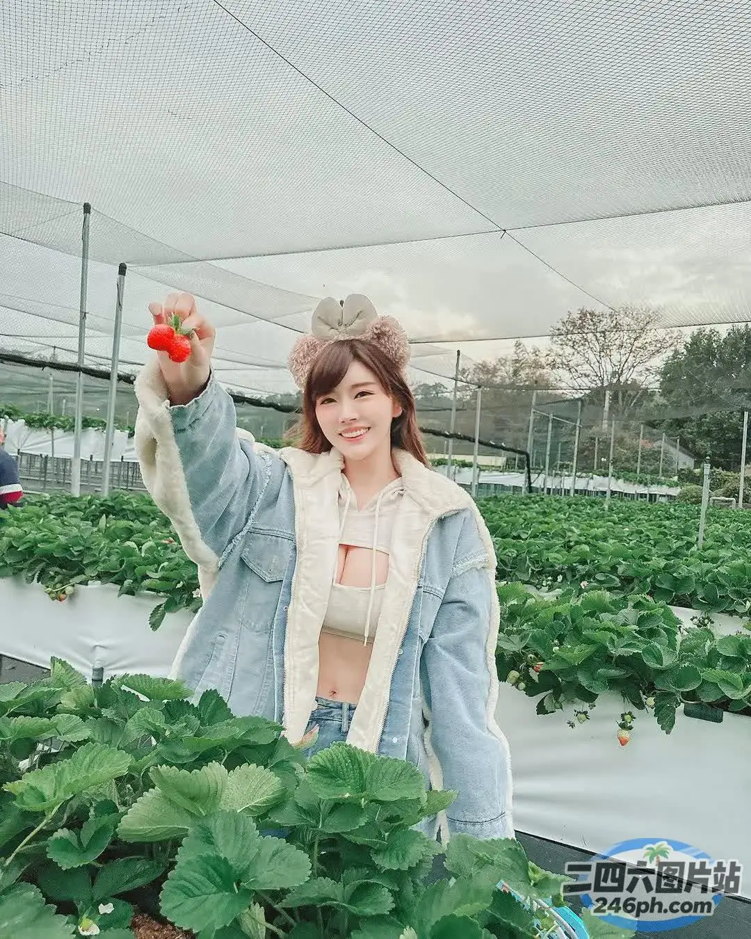 Araffe 女人在草莓园里拿着西红柿